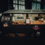 Czarny nowoczesny food truck z kawą oświetlony nocą