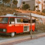 Czerwony food truck zaparkowany przy ulicy w Turcji pod markizą