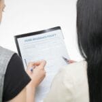 Dwie kobiety analizujące szczegóły polisy ubezpieczeniowej