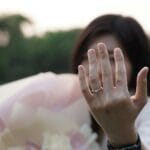 Kobieta prezentuje pierścionek zaręczynowy w plenerze