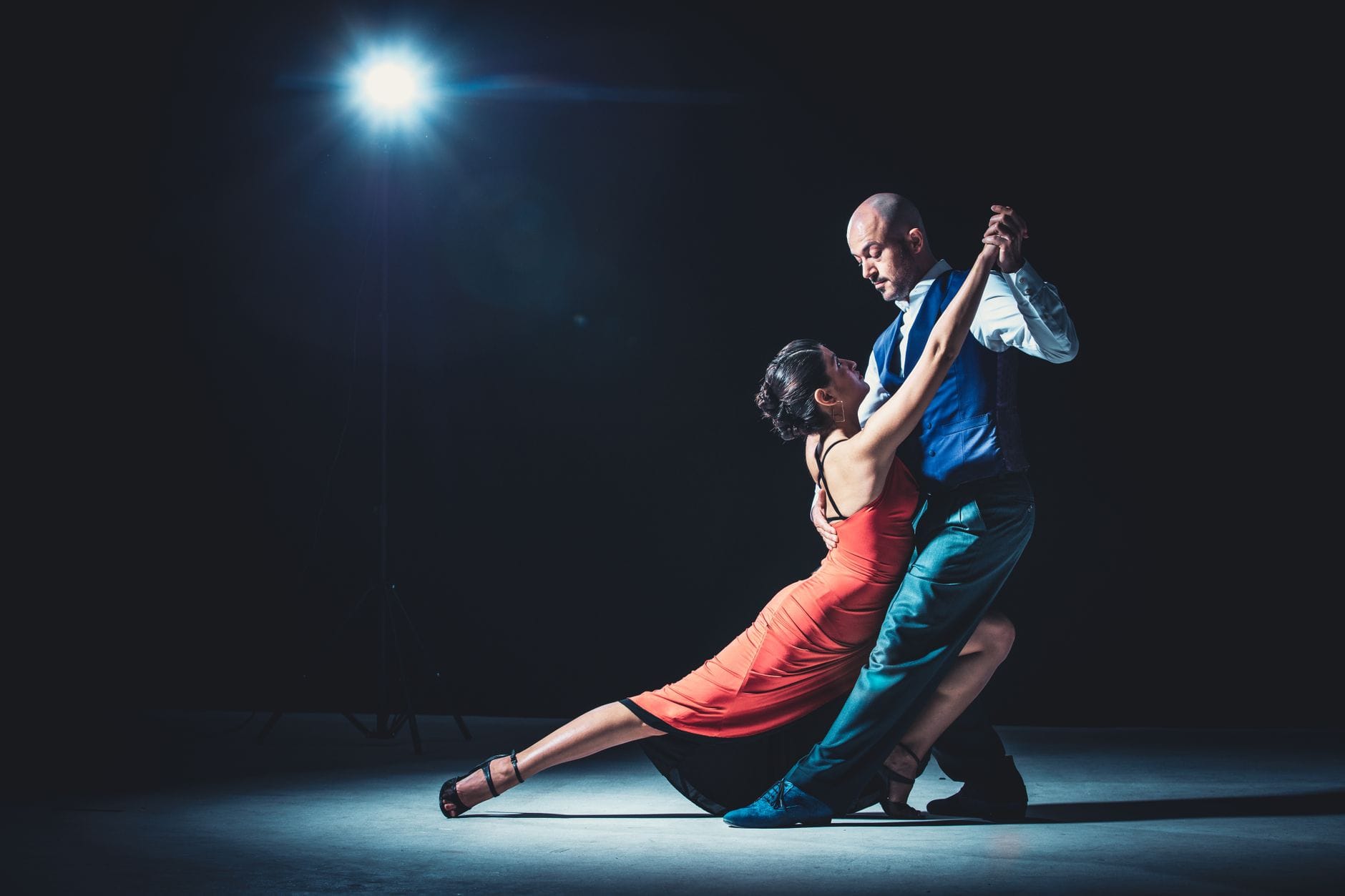 Elegancka para tańczy tango w świetle reflektorów na parkiecie
