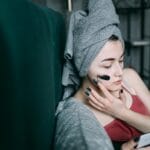 Kobieta w domu nakłada maseczkę na twarz jako część pielęgnacji skóry