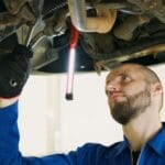 Mechanik podnosi auto na podnośniku i sprawdza stan sprzęgła