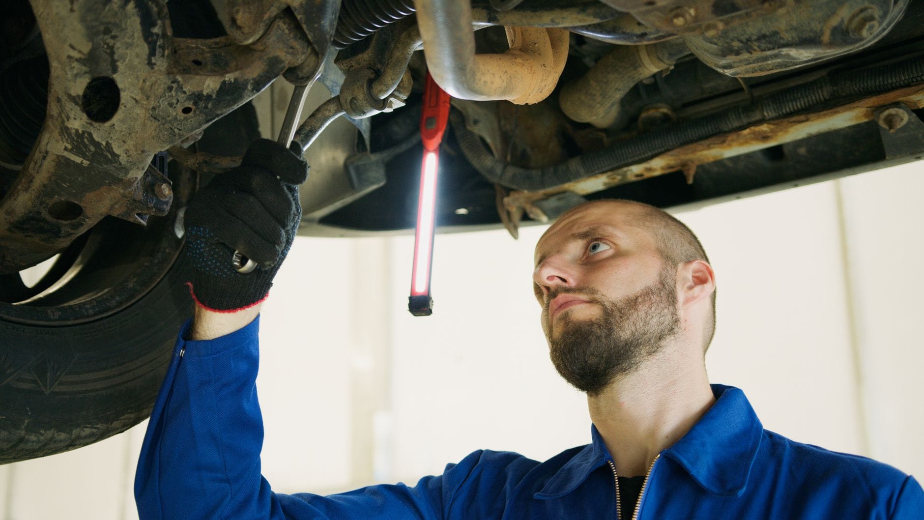 Mechanik podnosi auto na podnośniku i sprawdza stan sprzęgła