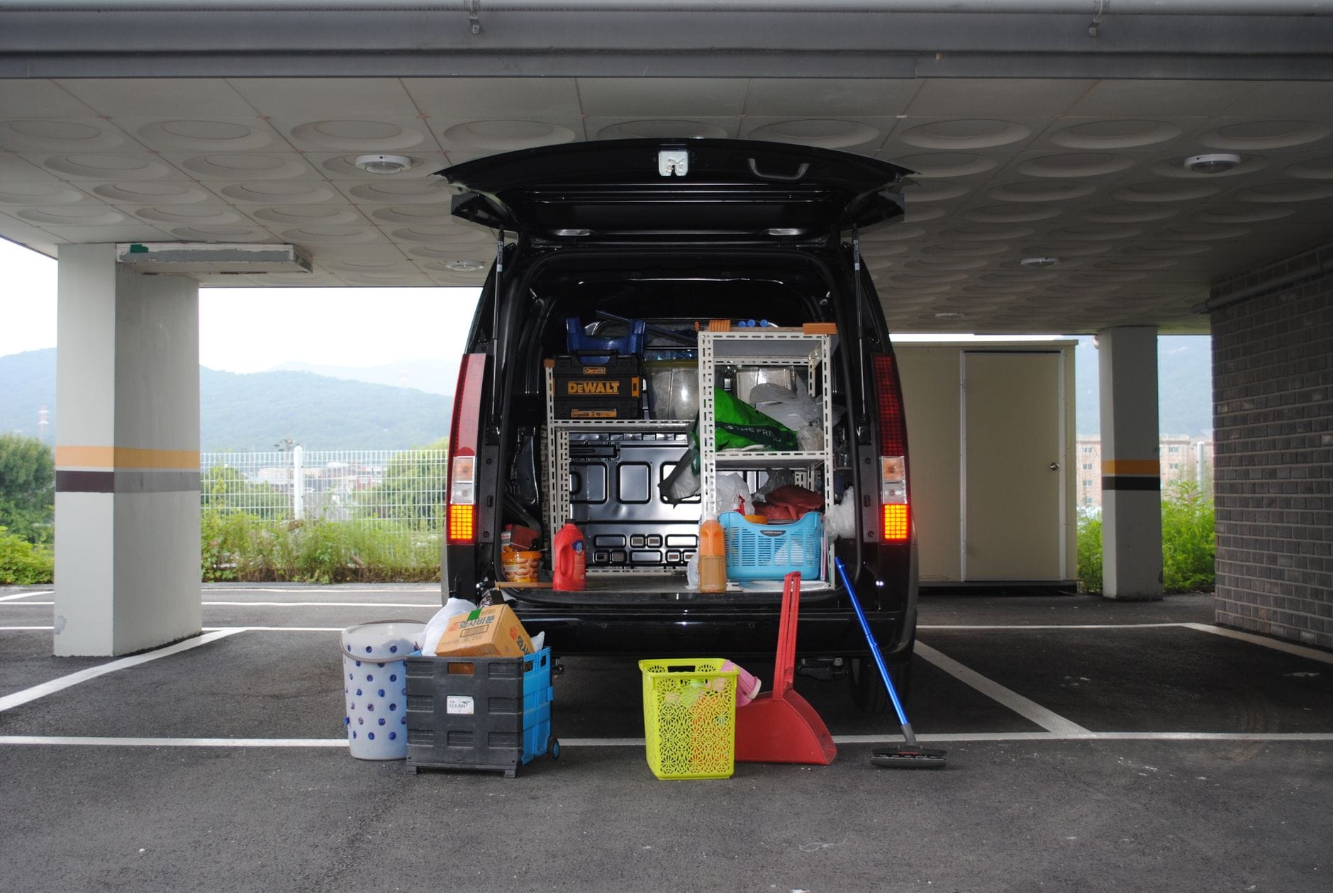 Tył czarnego busa z zabudową sprzętową na miejskim parkingu