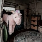 Wnętrze małego kampera VW z pluszowym różowym jednorożcem i dekoracjami
