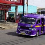 Fioletowy minibus komunikacji miejskiej na ruchliwej ulicy w Indonezji